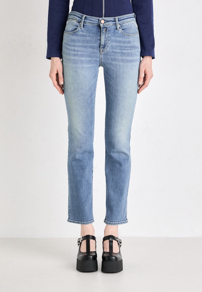 Light blue denim jeans with a slim fit, slightly faded design, and cropped length. Features five-pocket styling and a front button closure.