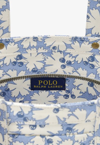 Μπλε ύφασμα εσωτερικού με σχέδιο από λευκά λουλούδια, διαθέτει χρυστό φερμουάρ και μπλε ετικέτα με την επιγραφή «POLO RALPH LAUREN».
