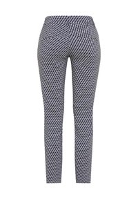 Pantalon slim avec motif géométrique noir et blanc, deux poches arrière et une taille mi-haute.