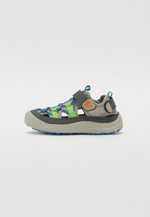 Sandal desportivo em cinza e azul-escuro com detalhes em verde, parte superior em malha, tiras ajustáveis e sola texturizada para aderência e estabilidade.