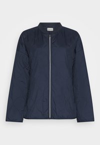 Giacca trapuntata blu navy con collo rotondo, chiusura con zip e motivo cucito a onde, dotata di maniche lunghe e una texture liscia.