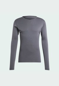 Chemise à manches longues de couleur gris foncé, fabriquée en tissu doux et lisse. Elle présente un col rond et une coupe ajustée, sans ornements.