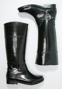 Czarne lakierowane kozaki do kolan z okrągłym srebrnym logo i gładką fakturą. Posiadają niski obcas oraz kontrastowe wstawki. 