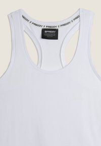 Canotta bianca senza maniche realizzata in tessuto morbido. Presenta una scollatura a U e una fascia con logo stampato nella parte superiore, con una texture liscia.