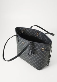 Dark tote bag with a patterned exterior, featuring a cinched opening, two sturdy handles, and an interior pocket visible inside.