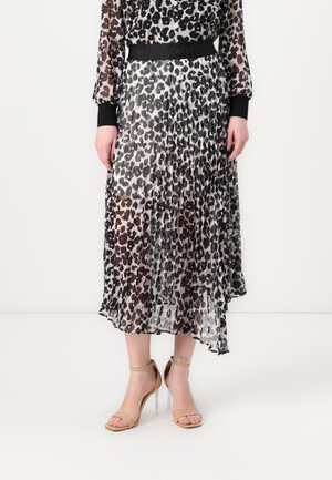 Pleated maxi skirt in sheer black and white leopard print, featuring a black elastic waistband. Paired with nude strappy heels.