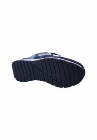 Sneaker blu navy con suola in gomma testurizzata, dotato di tomaia in materiali misti e un'accenno bianco minimalista sul lato. Motivo di battistrada robusto visibile.