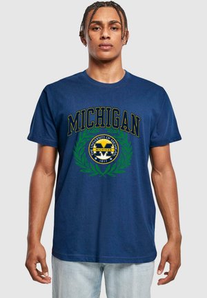 Navy blue cotton t-shirt featuring "MICHIGAN" text in yellow, with a circular emblem and green laurel design at the center. Relaxed fit.