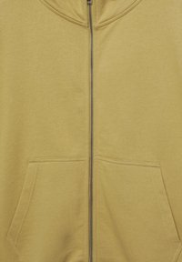 Gele hoodie met ritssluiting, gemaakt van zachte stof, met een hoge kraag, metalen rits en twee voorzakken.