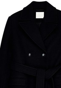 Melnas vilnas mētelis ar dubulto pogu aizdari, platiem atlokiem un sasietu jostu. Aprīkots ar lielām pogām un teksturētu audumu.