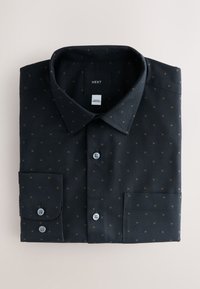 Dunkelblaues Hemd mit Knöpfen aus Stoff, das ein kleines, verstreutes Muster aus goldenen Punkten aufweist. Es hat einen Kentkragen und abgerundete Manschetten.