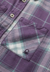 Camicia a quadri viola, bianca e turchese con bottone, dotata di taschino frontale ricamato con un piccolo logo nero.