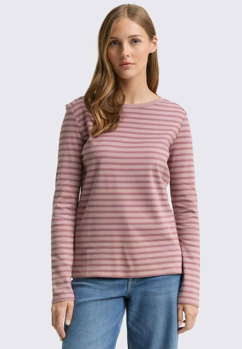 Top de manga larga a rayas en tejido suave de color rosa claro con rayas horizontales en rosa más oscuro; cuello redondo; combinado con jeans de mezclilla azul.