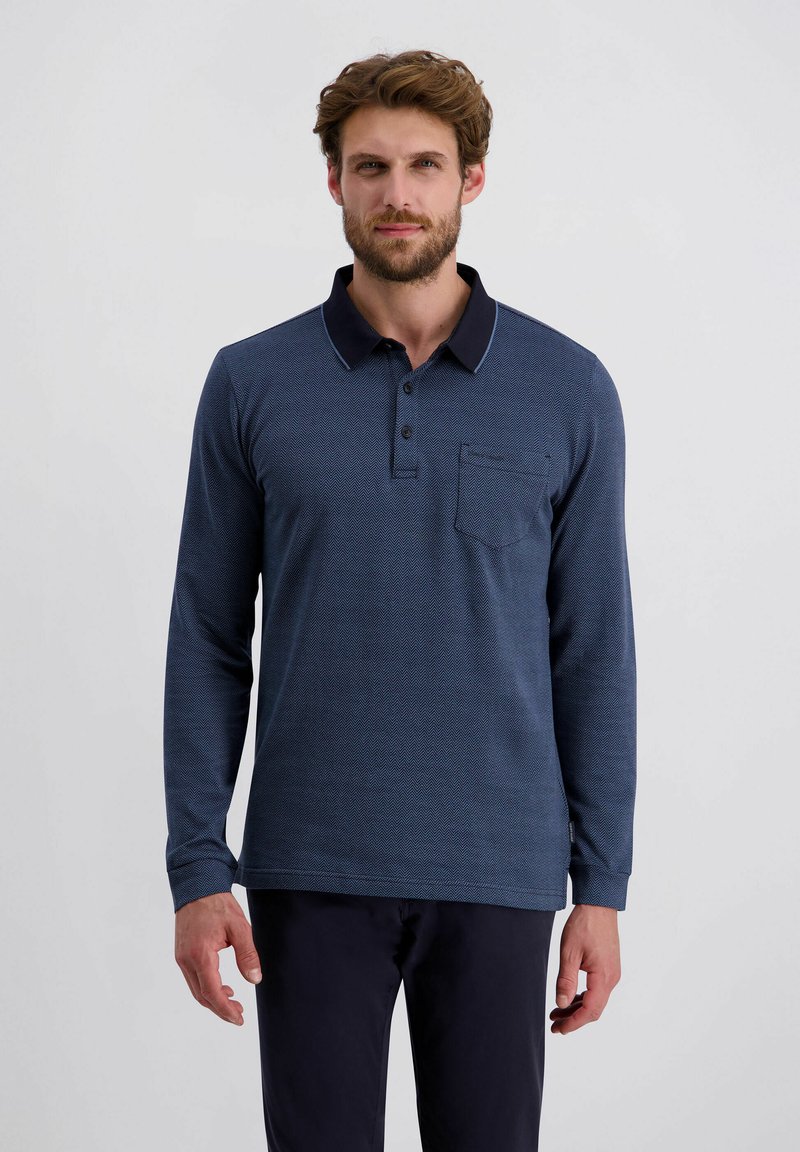 Navyblaues Langarm-Polohemd mit kontrastierendem Kragen, einem strukturierten Zickzack-Muster und einer Brusttasche. Hergestellt aus weichem Stoff.