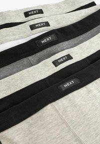 Set med fyra herrboxershorts i grått, svart och vitt. Varje har en tygmidja med en svart etikett där det står "NEXT" i vitt.