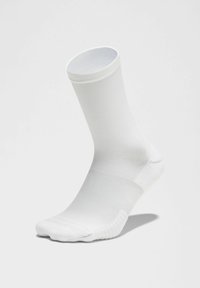 Baltas kulkšninis šlikas, pagamintas iš glotnaus, elastingo medžiagos, su raukšlėtu kraštu, turintis beplyšę kojų dizainą ir prigludusią formą.