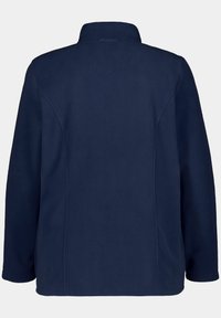 Laivaston fleece-takki, jossa on korkea kaulus, pitkät hihat ja pehmeä rakenne. Ominaisuuksiin kuuluu puhdas muotoilu ilman näkyvää metalliosia tai kuvioita.