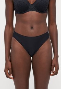 Schwarzes Unterwäsche-Set bestehend aus einem strukturierten BH und passenden hochgeschnittenen Bikini-Unterhosen, gefertigt aus glattem Stoff mit nahtlosem Design.