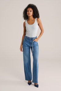 Grå linne kombinerat med blå vida denimjeans. Jeansen har dragsko i midjan, två sidofickor och en urtvättad look.