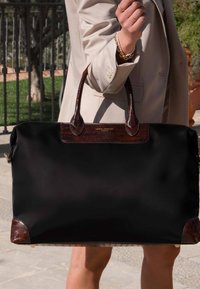 Grand sac fourre-tout noir en tissu avec des accents en cuir embossé crocodile marron. Dispose de deux poignées et d'une plaque logo en métal.
