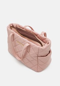 Różowa skórzana torebka z pikowaniem, ze złotymi elementami, podwójnymi uchwytami i zamknięciem na zamek błyskawiczny. Wnętrze wykończone gładką podszewką oraz z kieszeniami organizacyjnymi.