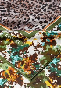 Seidenschal mit einem Leopardenmuster in Braun und Schwarz, überlagert von einem floralem Design mit grünem Rand in Orange, Weiß und Türkis.
