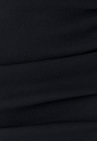 Tela negra texturizada con sutiles estrías, que presenta una superficie suave y lisa. El material parece ligero y cae con elegancia.