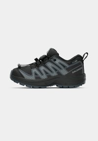 Schwarze Wanderschuhe mit einer strukturierten Oberfläche, reflektierenden grauen Streifen, einem Zugbandverschluss und einer robusten Sohle für besseren Halt.