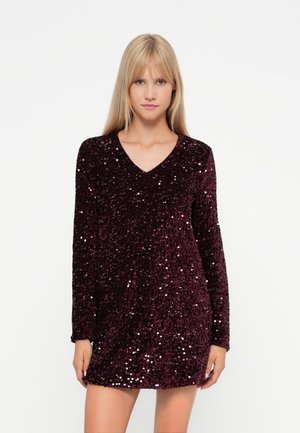 Robe en sequins bordeaux avec des manches longues et un décolleté en V. Texture douce avec des sequins brillants couvrant toute la surface, créant un effet scintillant.