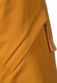 Gul tyg med en ficka som har dragkedja och orange dragkedjehandtag. Materialet har en strukturerad yta, vilket ger hållbarhet och ett modernt utseende.