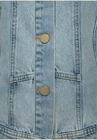 Giacca di jeans azzurro chiaro con bottoni a pressione metallici, due tasche frontali e cuciture a contrasto color nocciola lungo le cuciture.