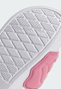 Σόλα παπουτσιού με λευκή βάση από καουτσούκ και υφή αντιολισθητικού μοτίβου. Ένα ροζ σημείο είναι προσαρτημένο στη φτέρνα, ενισχύοντας το σχέδιο.