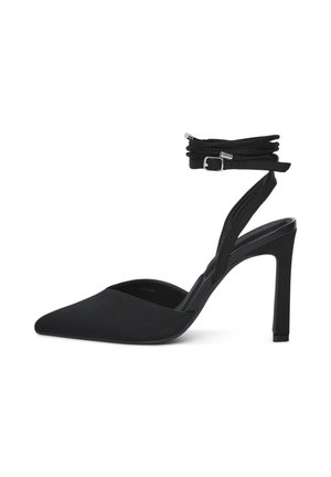 Scarpa nera con tacco alto e punta affilata, dotata di cinturini alla caviglia e una fibbia argentata, mostrata in profilo laterale su sfondo bianco.