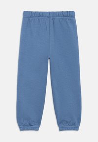 Blaue Jogginghose aus weichem Material mit elastischem Bund und elastischen Bündchen an den Knöcheln. Einfaches, schlichtes Design.