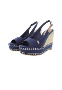 Námořnické modré wedges sandály s otevřenou špičkou, s popruhem kolem paty a viditelnými detaily prošití; zdůrazněné malým kovovým logem.