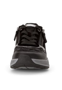 Zwarte sportschoen met veters en rits, een gestructureerde bovenkant, een gevoerde kraag en een dikke grijze rubberen zool.