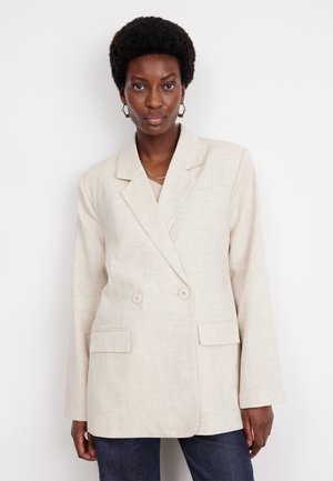 Blazer beige à double boutonnage en lin, avec deux poches avant et un col cranté. Manches longues avec une texture lisse.