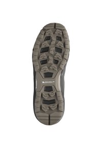 Semelle de chaussure de randonnée noire avec un design en caoutchouc robuste, des crampons profonds, une surface texturée et des accents gris. Logo Michelin visible.