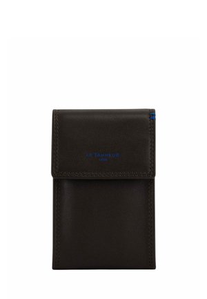 Portafoglio in pelle marrone scuro con chiusura a patta, testo del marchio blu sulla patta e piccolo dettaglio cucito blu nell'angolo in alto a destra.