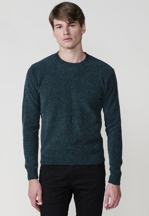 Donkergroene gebreide sweater met een ronde halslijn en lange mouwen. Heeft een textuurstof en geribde manchetten en zoom. Aansluitende pasvorm.
