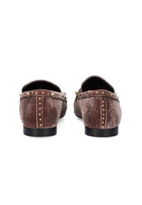 Mocasines de terciopelo marrón con tachuelas decorativas a lo largo de la parte trasera y los laterales, con forma redondeada y suelas planas negras.