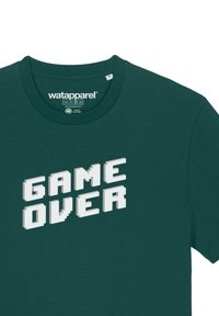 Donkergroene katoenen t-shirt met een witte gepixelde "GAME OVER" graphic centrisch op de voorkant. Klassiek crew neck ontwerp.