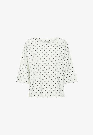Hvid kortærmet top med sorte prikker, rund halsudskæring og afslappet pasform. Blødt materiale med en glat overflade.