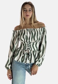 Blusa scollata con strisce verdi e bianche a onde, vita cintrata con dettagli allacciati e maniche lunghe a sbuffo. Tessuto testurizzato.