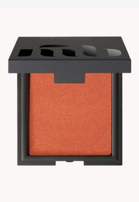 Blush arancione shimmer in una confezione quadrata con coperchio nero opaco. La scatola presenta un design con ritaglio per la visibilità del prodotto.