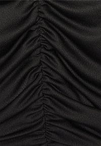 Tecido preto com pregas verticais proeminentes, textura suave e acabamento liso, criando uma aparência franzida em todo o material.