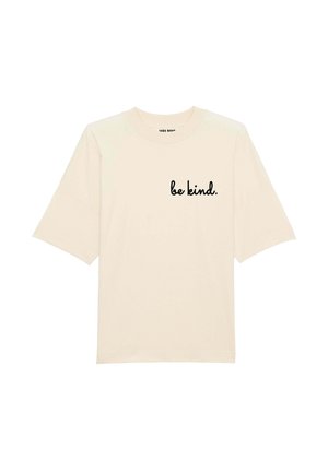 T-shirt en coton beige avec des manches courtes et larges. Présente le texte "sois gentil." en cursive noire sur le devant. Design simple et épuré.