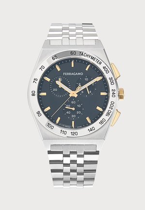 Montre-bracelet Ferragamo argentée avec cadran noir, aiguilles et index dorés, lunette tachymétrique, trois sous-cadrans et bracelet à maillons en métal.