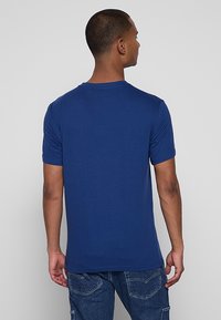 Marineblaues Kurzarm-T-Shirt mit Rundhalsausschnitt und glatter Textur, das ein minimalistisches Design und eine einfarbige Optik aufweist.