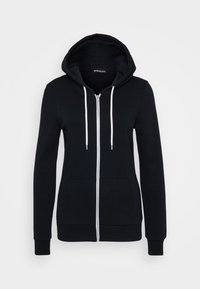 Sudadera con cremallera negra hecha de algodón, con un bolsillo frontal, capucha con cordón y cremallera y cordones blancos. Textura suave.